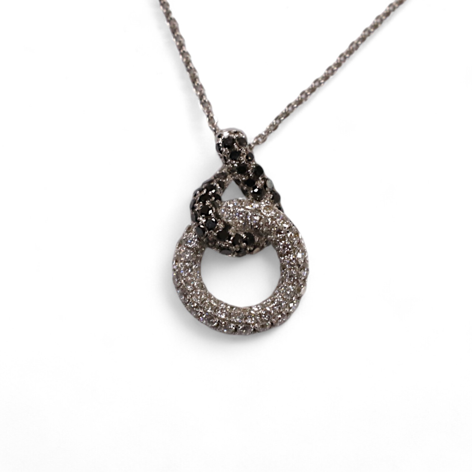 A modern 18k white metal and diamond chip set double loop pendant, 20mm, on an 18k white metal chain, 40cm, gross weight 4.1 grams. Condition - fair